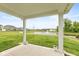 Covered back porch showcasing views of a pond with a fountain and well-maintained green lawn and neighboring houses at 3980 Railhead Ave, Westfield, IN 46074