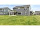 Exterior view of the home highlighting a well-manicured backyard, a covered porch, and neutral siding at 3980 Railhead Ave, Westfield, IN 46074