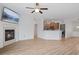 Bright living room with hardwood floors, fireplace, ceiling fan, and an open view to the kitchen at 4261 Washington Blvd, Plainfield, IN 46168