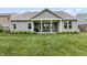 Backyard showcasing a covered patio with outdoor seating and a lush green lawn at 4428 Maldenhair Dr, Indianapolis, IN 46239