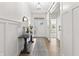 Bright entryway boasts light hardwood floors, stylish console table and paneled walls at 4428 Maldenhair Dr, Indianapolis, IN 46239