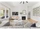 Bright living room with fireplace, hardwood flooring, comfortable seating, and wall art, with natural light from windows at 4428 Maldenhair Dr, Indianapolis, IN 46239
