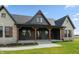 Up close exterior showcasing stone, dark siding, and a covered front porch with wood columns at 4457 E County Road 850 N, Pittsboro, IN 46167