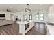 Open-concept kitchen with island, stainless appliances and dark hardwood floors, connecting to the living room at 4457 E County Road 850 N, Pittsboro, IN 46167