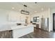 Bright kitchen features white cabinetry, quartz countertops, stainless steel appliances, and a large center island at 4457 E County Road 850 N, Pittsboro, IN 46167