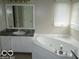 Bathroom with a jacuzzi tub, white cabinets, and window at 4667 Sundance Trl, Indianapolis, IN 46239