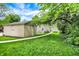 Serene backyard with lush greenery, a charming pathway, and outbuildings at 5104 Carvel Ave, Indianapolis, IN 46205