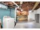 Unfinished basement area with laundry, a cat platform, storage and blue painted wall at 5104 Carvel Ave, Indianapolis, IN 46205