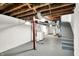 Unfinished basement with painted concrete walls, exposed ceiling with stairs and utilities at 5104 Carvel Ave, Indianapolis, IN 46205