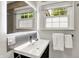 Bathroom with a sleek black vanity, vessel sink, and large mirror with a window view at 5104 Carvel Ave, Indianapolis, IN 46205