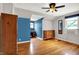 Bedroom featuring hardwood floors, natural light, a ceiling fan and blue accent wall at 5104 Carvel Ave, Indianapolis, IN 46205