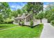 A charming two-story home is nestled in a lush green setting, complete with a gravel driveway and detached garage at 5104 Carvel Ave, Indianapolis, IN 46205