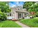 A charming two-story home with neutral siding, black shutters, a white picket fence, and a cozy screened porch at 5104 Carvel Ave, Indianapolis, IN 46205