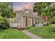 A charming two-story home with neutral siding, black shutters, a cozy screened porch and well-manicured lawn at 5104 Carvel Ave, Indianapolis, IN 46205