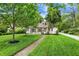 A charming two-story home with neutral siding, black shutters, a cozy screened porch and a gravel driveway at 5104 Carvel Ave, Indianapolis, IN 46205