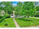 A charming two-story home with mature trees, a well-manicured lawn, and a walkway leading to the front door at 5104 Carvel Ave, Indianapolis, IN 46205