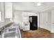 Bright kitchen with white cabinets, a window, and black appliances at 5104 Carvel Ave, Indianapolis, IN 46205