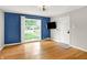 Living room featuring hardwood floors, a large window, and a modern ceiling fan at 5104 Carvel Ave, Indianapolis, IN 46205
