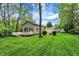 Expansive yard with well-maintained lawn, mature trees, and a deck, offering outdoor space at 5104 Carvel Ave, Indianapolis, IN 46205