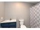 Bathroom featuring blue vanity, updated fixtures, and a shower with a patterned curtain at 521 Sunset Dr, Edinburgh, IN 46124