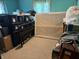 Bedroom with turquoise walls filled with stacked storage boxes and furniture at 5585 Gallagher Dr, Greenwood, IN 46142