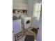 Well-lit laundry room with washer, dryer, storage, and decorative rug near an exterior door at 5585 Gallagher Dr, Greenwood, IN 46142