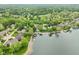 Aerial shot of a lakeside home with a pool and dock surrounded by lush trees at 5786 E Fall Creek Pkwy N Dr, Indianapolis, IN 46226