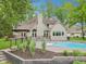 Expansive backyard with a pool and lush landscaping surrounding a beautiful brick home at 5786 E Fall Creek Pkwy N Dr, Indianapolis, IN 46226