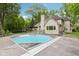 Exterior of home features a swimming pool, neutral brick, chimney, deck and lush landscaping at 5786 E Fall Creek Pkwy N Dr, Indianapolis, IN 46226
