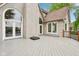 Exterior backyard view of home featuring a patio, arched windows, and white brick at 5786 E Fall Creek Pkwy N Dr, Indianapolis, IN 46226