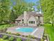 Beautiful home with a swimming pool and well-maintained backyard, complemented by mature trees at 5786 E Fall Creek Pkwy N Dr, Indianapolis, IN 46226