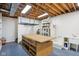Unfinished basement area with a workbench, sink, and built-in shelving at 5786 E Fall Creek Pkwy N Dr, Indianapolis, IN 46226