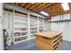 Unfinished basement area with built-in shelving and a workbench at 5786 E Fall Creek Pkwy N Dr, Indianapolis, IN 46226