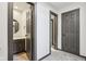 Hallway with entry to half bath with vanity with neutral paint and tile at 5786 E Fall Creek Pkwy N Dr, Indianapolis, IN 46226