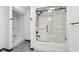 Bright bathroom showcasing a shower with glass doors, built-in shelving, and modern fixtures at 5786 E Fall Creek Pkwy N Dr, Indianapolis, IN 46226