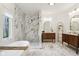 Bright bathroom with marble walls, wood accents, a standing shower, and a soaking tub at 5786 E Fall Creek Pkwy N Dr, Indianapolis, IN 46226