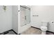 Well-lit bathroom featuring a shower with sliding glass doors, a toilet, and light-colored tiling at 5786 E Fall Creek Pkwy N Dr, Indianapolis, IN 46226
