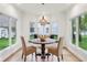 Bright breakfast nook featuring a bay window, wooden table, two woven chairs and hardwood flooring at 5786 E Fall Creek Pkwy N Dr, Indianapolis, IN 46226