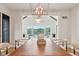 Bright dining room with modern chandelier, large windows with lake views, and hardwood floors at 5786 E Fall Creek Pkwy N Dr, Indianapolis, IN 46226