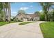 Expansive driveway leading to a gray brick home with a well-manicured lawn, wooden shutters and lush green trees at 5786 E Fall Creek Pkwy N Dr, Indianapolis, IN 46226