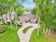 Beautiful home exterior with lush landscaping, circular driveway, and a view of the lake at 5786 E Fall Creek Pkwy N Dr, Indianapolis, IN 46226