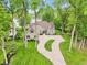 Stunning exterior view of home with landscaped yard, circular drive, and lake in the background at 5786 E Fall Creek Pkwy N Dr, Indianapolis, IN 46226