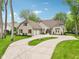 Charming two-story home with a circular driveway, attached garages, and beautifully landscaped front yard at 5786 E Fall Creek Pkwy N Dr, Indianapolis, IN 46226