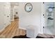 Hallway with light wood floors, closet with wire shelving, and accent ottoman at 5786 E Fall Creek Pkwy N Dr, Indianapolis, IN 46226