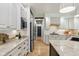 Bright kitchen featuring white cabinetry, granite counters, stainless appliances, and wood floors at 5786 E Fall Creek Pkwy N Dr, Indianapolis, IN 46226