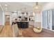 Kitchen showcasing white cabinets, a black kitchen island with stools and a view into the breakfast nook at 5786 E Fall Creek Pkwy N Dr, Indianapolis, IN 46226