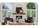 Bright living room featuring a stone fireplace, arched windows with lake views and hardwood floors at 5786 E Fall Creek Pkwy N Dr, Indianapolis, IN 46226