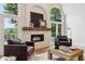 Open living room showcasing a stone fireplace, modern decor, hardwood floors and views of the outdoors at 5786 E Fall Creek Pkwy N Dr, Indianapolis, IN 46226