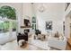 Open-concept living room featuring a fireplace, stylish decor, white walls, wood floors, and lots of natural light at 5786 E Fall Creek Pkwy N Dr, Indianapolis, IN 46226