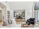 Inviting living room with hardwood floors, built-in shelves, and a view into the dining area at 5786 E Fall Creek Pkwy N Dr, Indianapolis, IN 46226